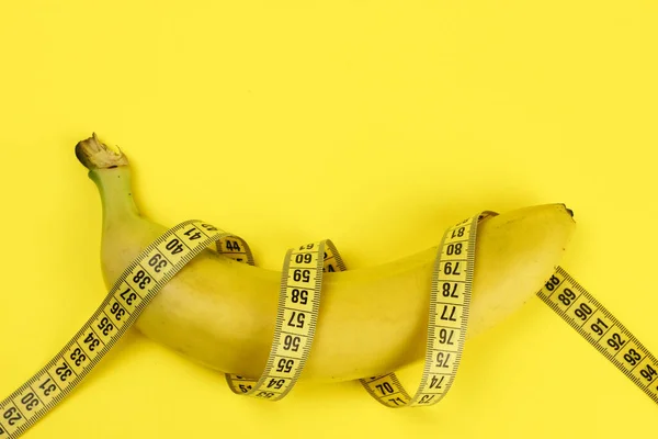 Banane Mit Maßband Auf Gelbem Hintergrund Ein Konzept Der Gewichtsabnahme — Stockfoto