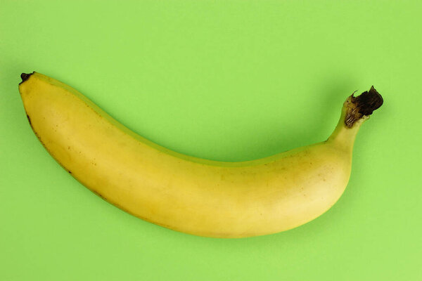 Ripe banana on a green background