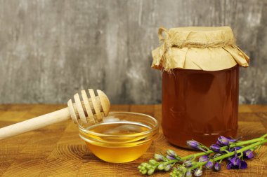 Tahtada bir sopayla kasedeki bal