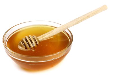 Beyaz arka planda izole edilmiş tahta bir sopayla kasedeki bal.