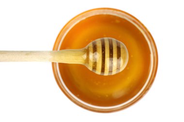 Beyaz arka planda izole edilmiş tahta bir sopayla kasedeki bal.