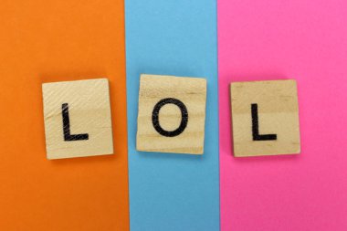 LOL - Renkli bir arka planda yüksek sesle ahşap harflerle gülün