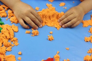 Kinetik kum. Çeşitli şekillerde kumdan kale inşa eden çocuk