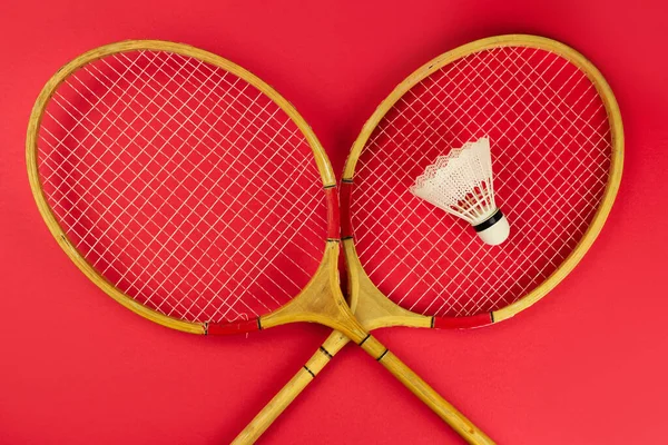 亮红色背景的羽毛球球拍和羽毛球 — 图库照片