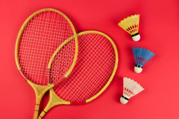 亮红色背景的羽毛球球拍和羽毛球 — 图库照片