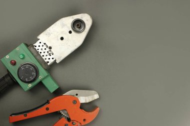 Gri arkaplanda PVC borular ve makas için lehimleme demiri