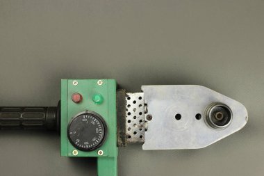 Gri arka plandaki PVC boruları için lehimleme demiri