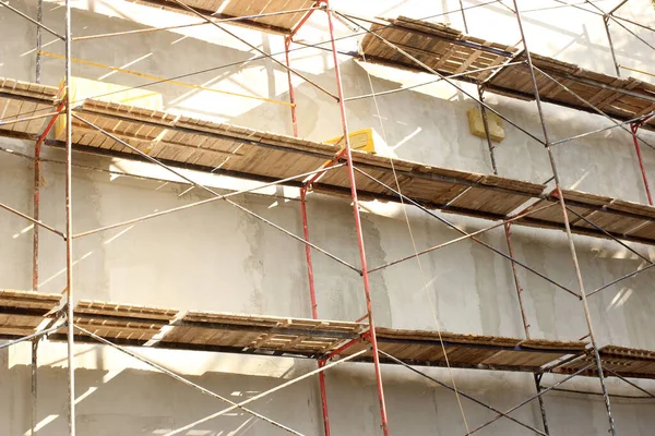 Çok katlı bir binanın yanına inşaat iskelesi, duvar yalıtımı, onarım işleri.