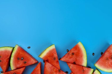 Mavi arkaplanda tohumları olan olgun karpuz dilimleri, metin için alanı kopyala