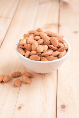 Ahşap masa, select odak alan sığ derinliği karşı seramik bir kasede badem fındık