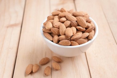 Ahşap masa, select odak alan sığ derinliği karşı seramik bir kasede badem fındık