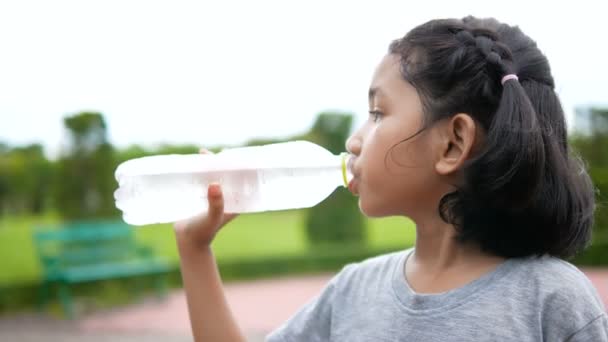 可爱的亚洲小女孩饮用水与幸福在自然公园 — 图库视频影像