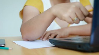 Dizüstü bilgisayar yazan ve kağıt metaforu ve iş pazarlama kavramına kalem yazan kadınların elleri