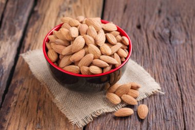 Ahşap masa, select odak alan sığ derinliği karşı seramik bir kasede badem fındık