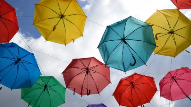 4K多彩的雨伞挂在乌云密布的蓝天上 — 图库视频影像