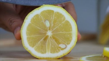 Kadının mutfak bıçak dilim kesip taze limon ahşap kesme tahtası üzerinde kullanarak atış eller yukarı kapatın