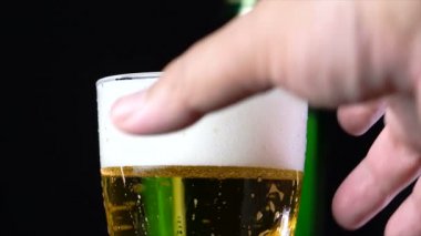 Bardağa köpüklü bira dökülüyor.