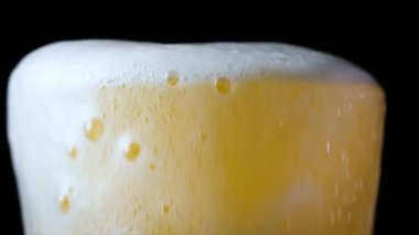 Bardağa köpüklü bira dökülüyor.