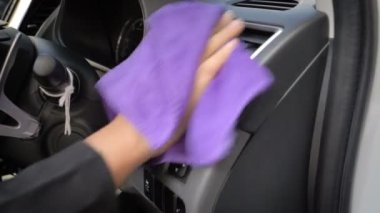 Suv araba ön panel iç temizlemek için mor mikro fiber kumaş kullanan kadın shot el kadar kapatın