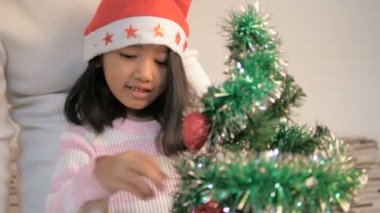 Bir Noel ağacı süsleme ve mutluluk ile dans Asyalı küçük kız
