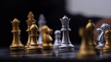 4k yakın çekim yukarı altın ve gümüş satranç oynayan adamın elleri odak alan sığ derinliği seçin.