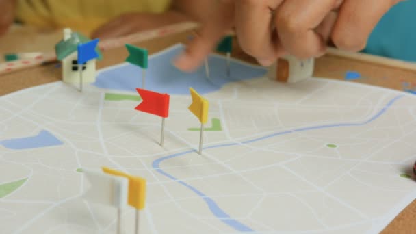 Detailní záběr záběr rukou dětí a matky připnutí barevný špendlík na mapu metafora plánování přepravy a cestování