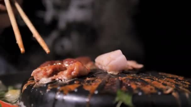 Lidé Pomocí Hůlky Vaření Pick Překlopit Vepřové Splní Korejský Bbq — Stock video