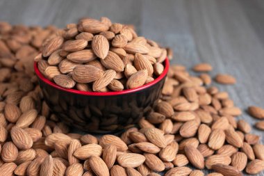 Ahşap arka plan se karşı siyah bir kase badem somun yığını