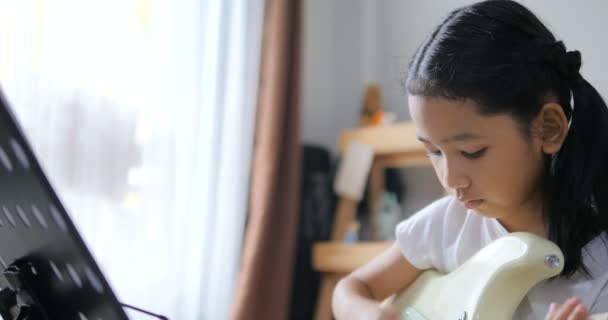 Asiática Niña Aprendiendo Tocar Guitarra Básica Mediante Uso Guitarra Eléctrica — Vídeo de stock