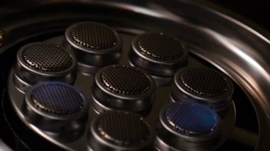 Karanlık ve tane işlenmiş karanlıkta gaz sobası üzerinde yanan ateş için yakın çekim başlangıç ateşleme