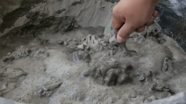 İnşaat için suyla çimento karıştıran işçiler