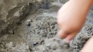 İnşaat için suyla çimento karıştıran işçiler
