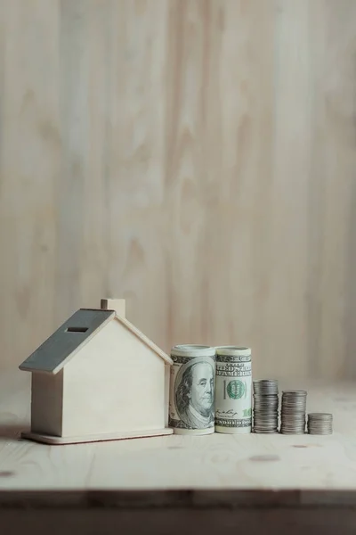 Maison en bois tirelire avec de l'argent en dollar et pièce de monnaie sur onglet en bois — Photo