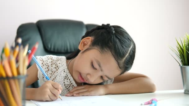 教育の概念のための幸福と宿題や笑顔を行う紙に書くために鉛筆を使用して小さなアジアの女の子は フィールドの浅い深さを選択します — ストック動画