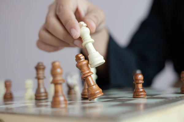 Закройте руку бизнес-леди, играющей на шахматной доске — стоковое фото