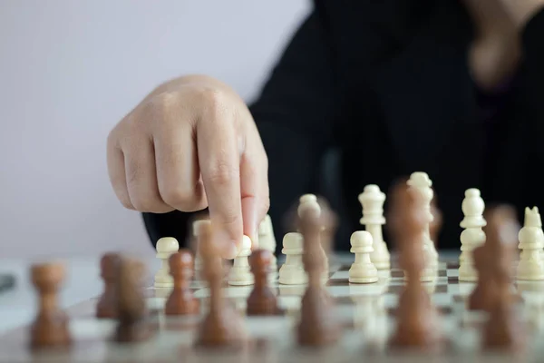 Закройте руку бизнес-леди, играющей на шахматной доске — стоковое фото