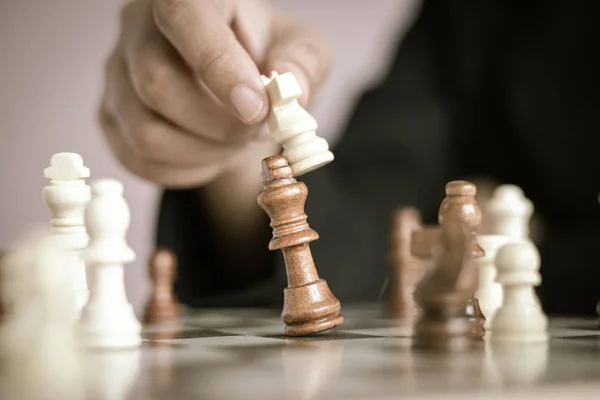 Close up shot hand of business woman playing the chess board to