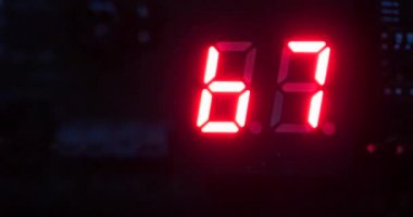 Karanlık ve tane işlenmiş elektronik baskılı devre kartında yakın çekim Led dijital sayı durum göstergesi