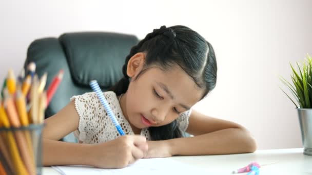 Malá Asijská Dívka Pomocí Tužky Psát Papír Dělat Domácí Úkoly — Stock video