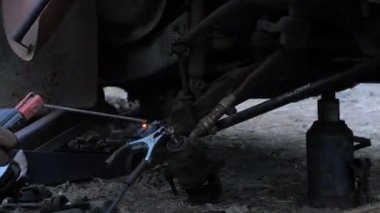  Lades kemiği kontrol kolunu onarmak ve arabanın ön tekerleğini değiştirmek için kamyonu kaynaklamak için kaynakçı kullanan tamirci