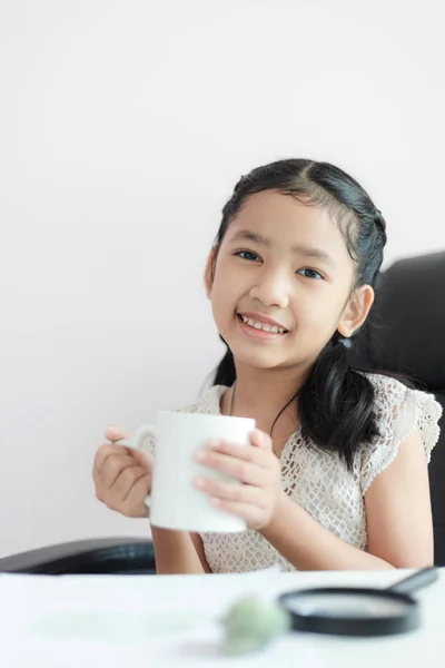 Маленька Азіатська дівчина тримає білу кухоль і посмішка з щастям SEL — стокове фото