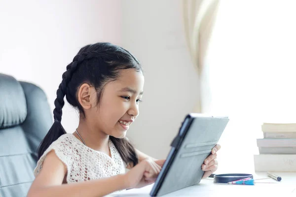 Pequeña chica asiática usando tableta y sonrisa con felicidad para educ —  Fotos de Stock