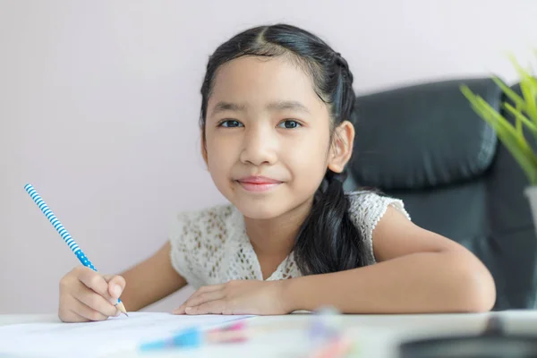 Gadis Asia kecil menggunakan pensil untuk menulis di atas kertas melakukan h — Stok Foto