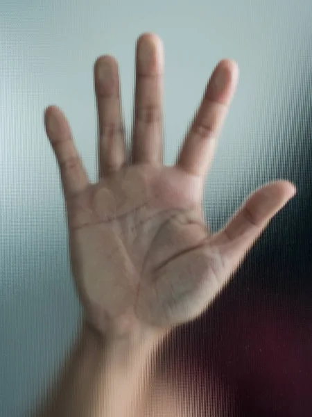 Blurry woman hand behind frosted glass metaphor panic and negati — Stock Photo, Image