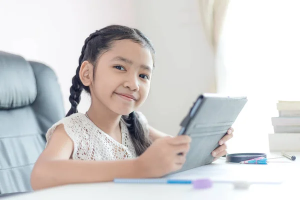 Pequeña chica asiática usando tableta y sonrisa con felicidad para educ —  Fotos de Stock