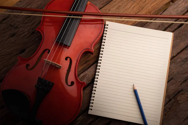 Крупный план скрипичный оркестр инструментальный и ноутбук над Во — стоковое фото
