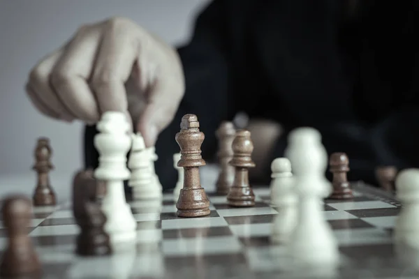 Close up shot hand of business woman playing the chess board to