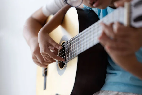 Madre enseñando a la hija a tocar en clase acústica — Foto de Stock