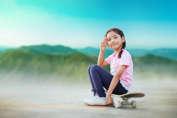 Asiática menina sentada no skate e sorrir com felicidade — Fotografia de Stock