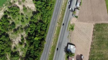 Yol üzerinde bir araba ve kamyonla kırsal otoyol trafiğinin hava manzaralı manzarası.